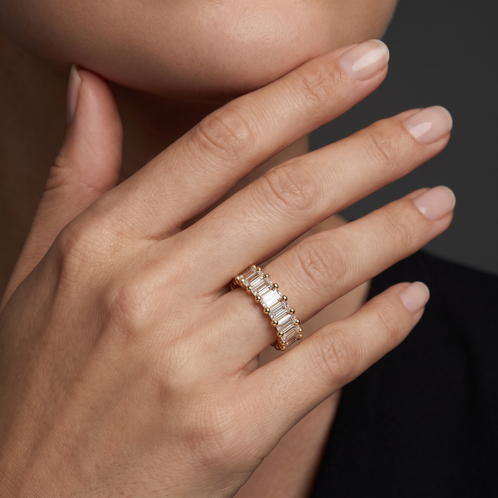 Emerald cut diamond wedding band worn on the ring finger, showing how band width reads on the hand