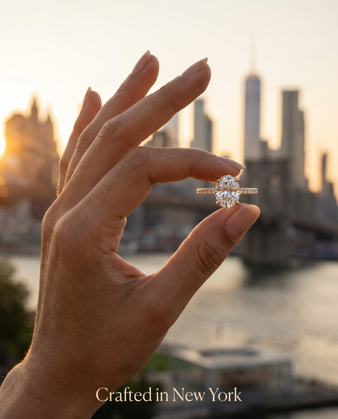 Oval thin band engagement ring held against NYC skyline at sunset — handcrafted in New York City — Black Pearl of Queens