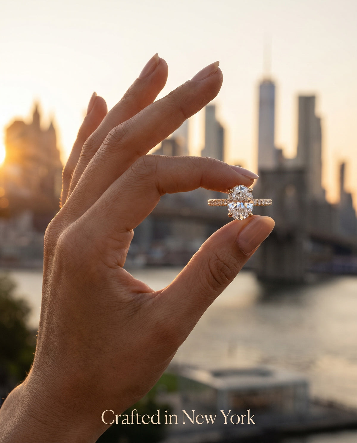 Oval thin band engagement ring held against NYC skyline at sunset — handcrafted in New York City — Black Pearl of Queens