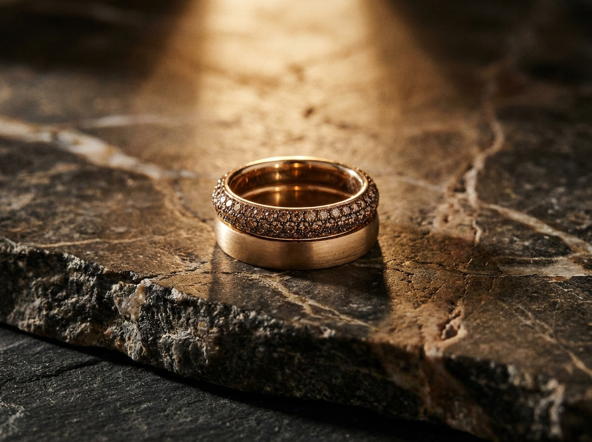 Pavé cognac diamond band stacked with plain gold band on dark slate — Brownstone Wedding Bands by Black Pearl of Queens