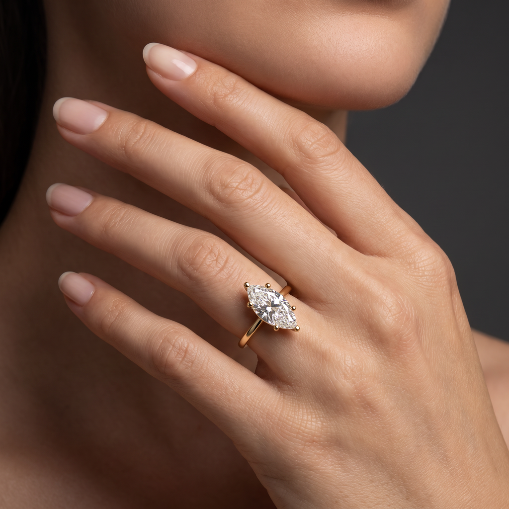 1.5ct marquise cut diamond solitaire in 14K yellow gold worn on the hand, showing the stone's length along the finger