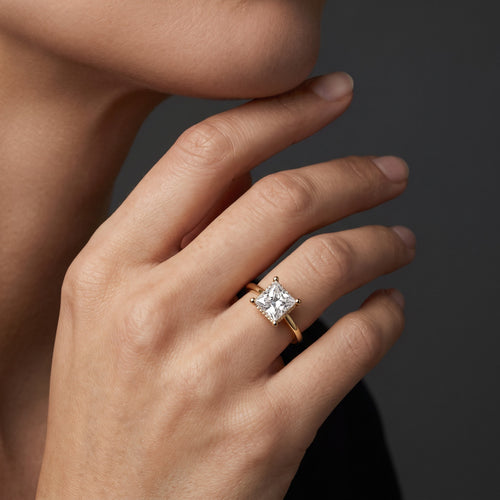 Hand wearing a 1.5 carat princess cut Lab-Grown Diamond hidden halo engagement ring in 14K yellow gold