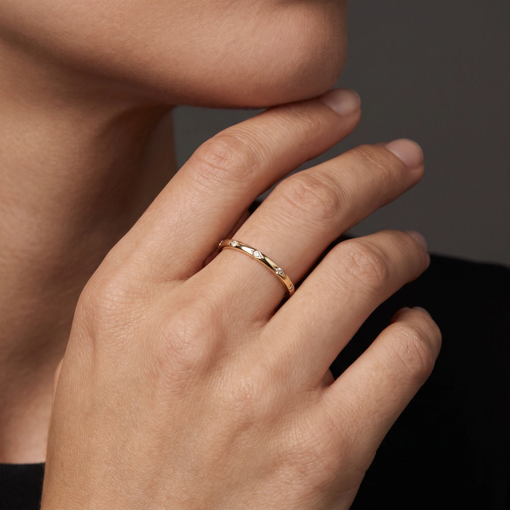 Woman wearing the 1.5mm star-set Lab-Grown Diamond band in 14K yellow gold
