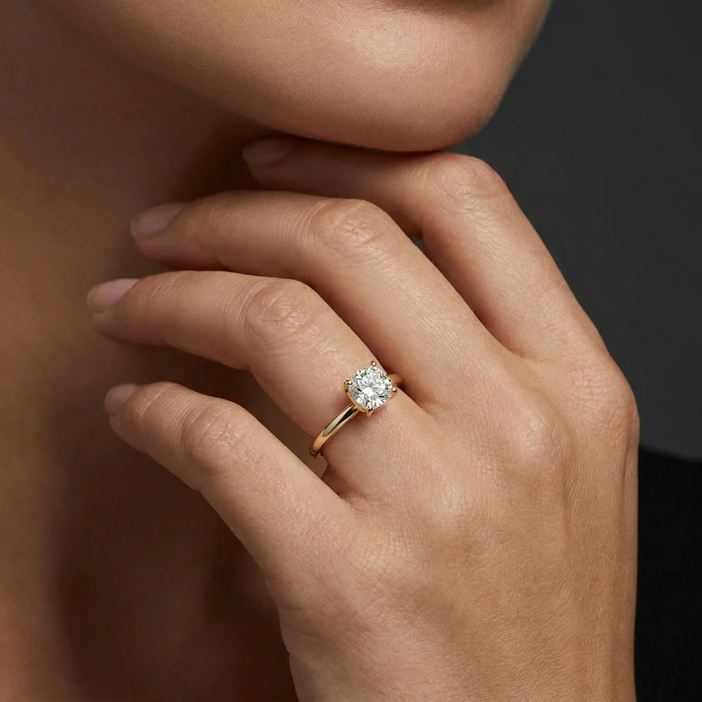 1 carat cushion cut lab grown diamond engagement ring in 14K yellow gold worn on hand