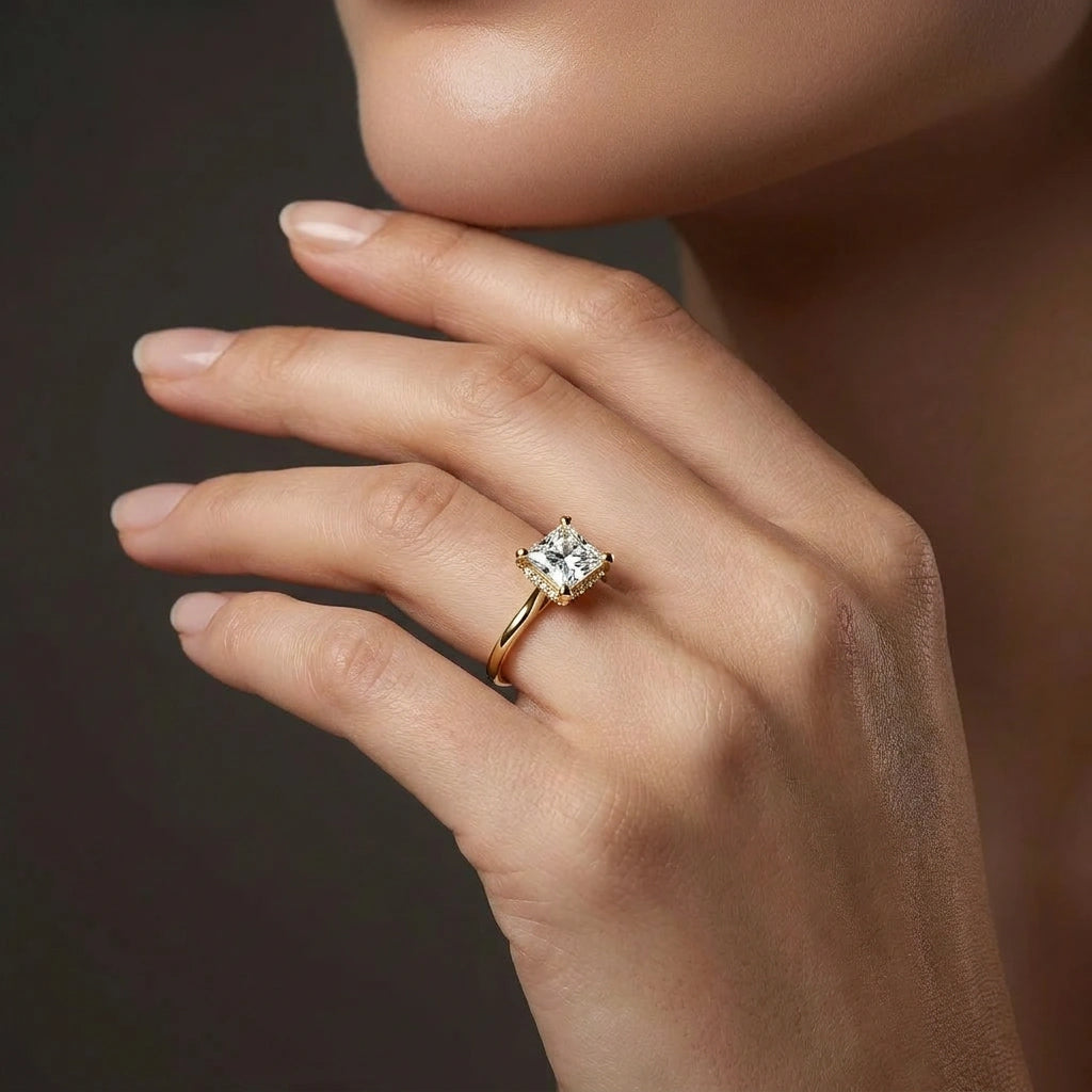 Woman wearing 1 carat princess cut hidden halo lab grown diamond ring in 14K yellow gold