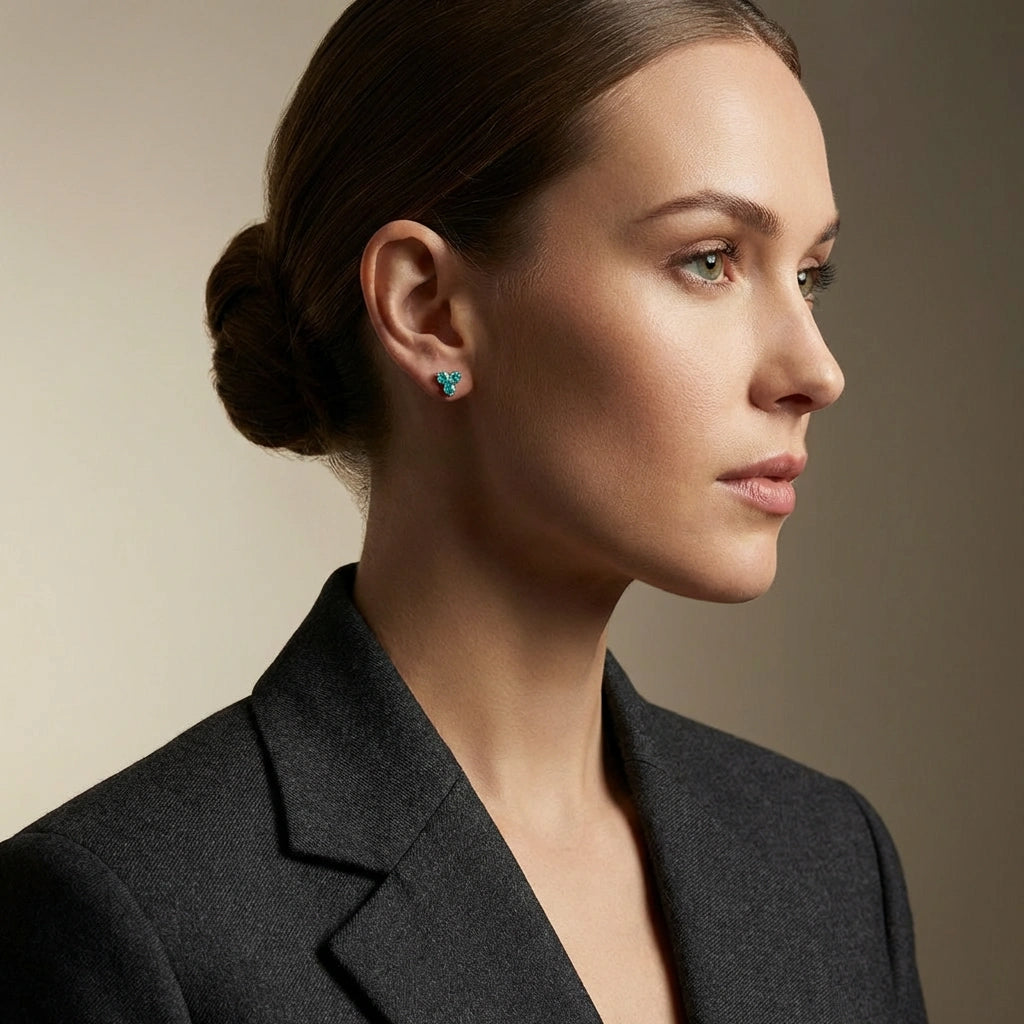Close-up of 14K gold turquoise stud earrings on model against dark studio background