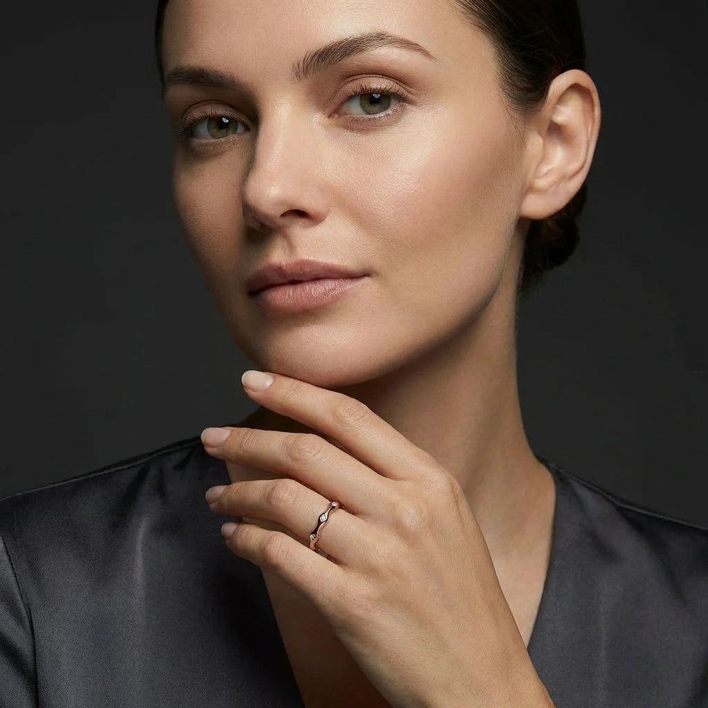 Woman wearing 14K rose gold wave diamond ring in portrait view