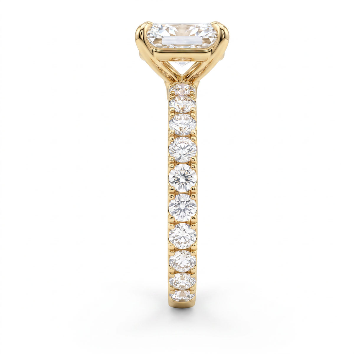 Side profile of 1ct emerald cut French pave engagement ring in 14K yellow gold showing minimal metal between the stones