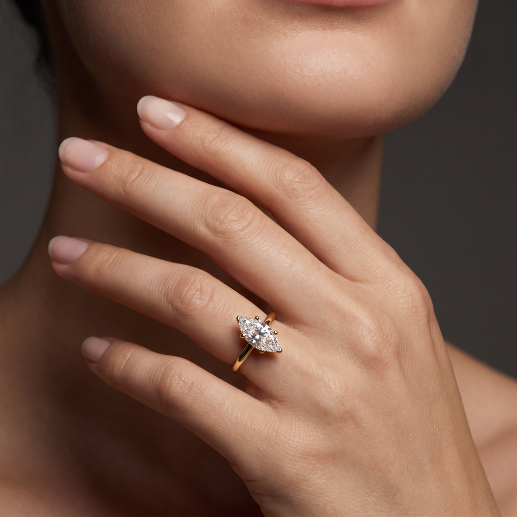 1ct marquise solitaire engagement ring in 14K yellow gold worn on hand, stone running lengthwise along the finger