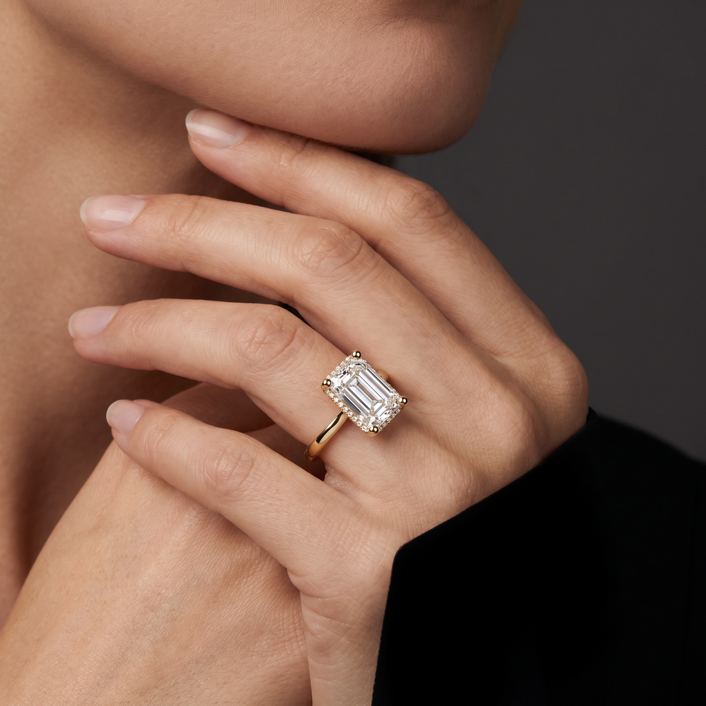 Hand wearing a 2.5 carat emerald cut Lab-Grown Diamond hidden halo engagement ring in 14K yellow gold