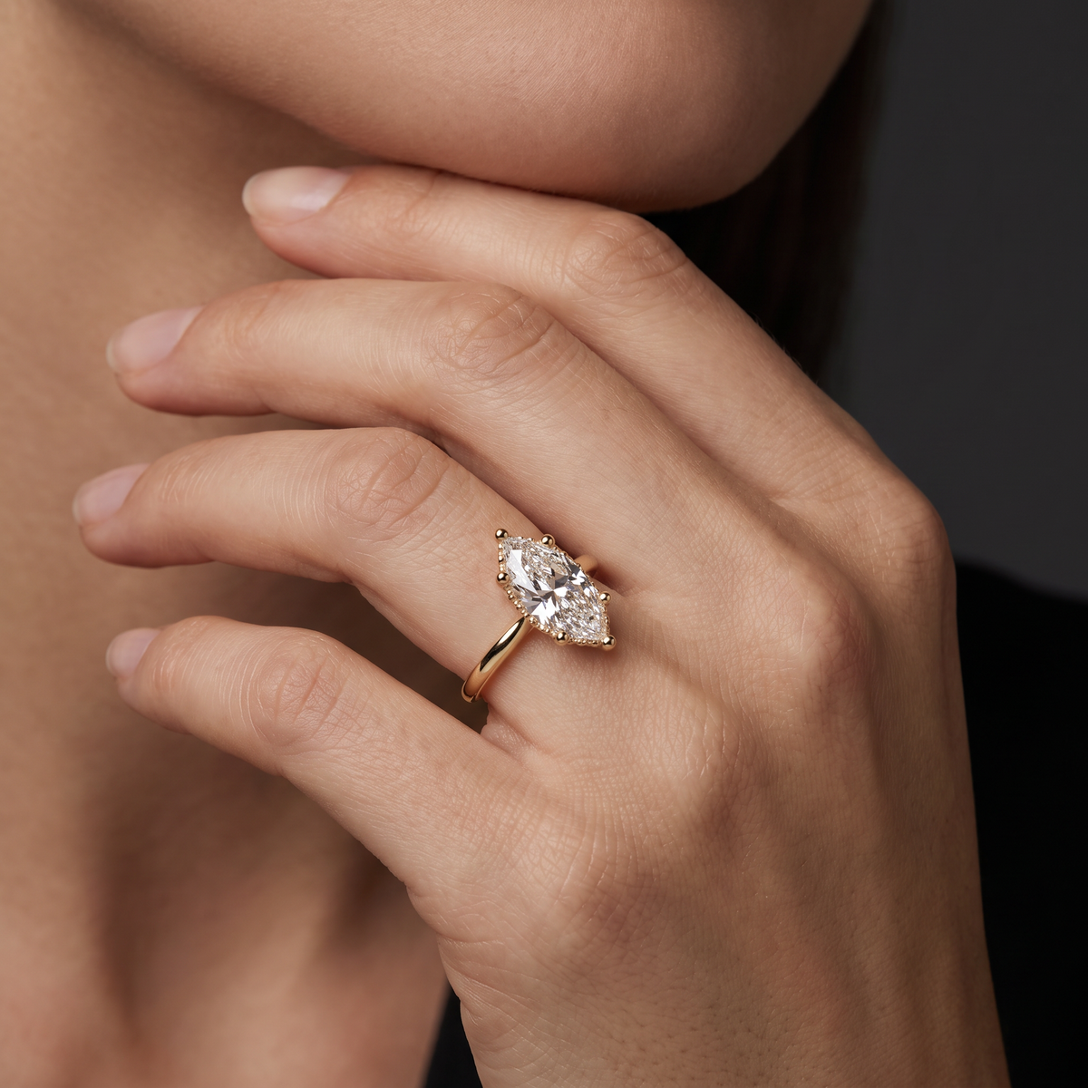 Hand wearing a 2.5 carat marquise Lab-Grown Diamond hidden halo engagement ring in 14K yellow gold