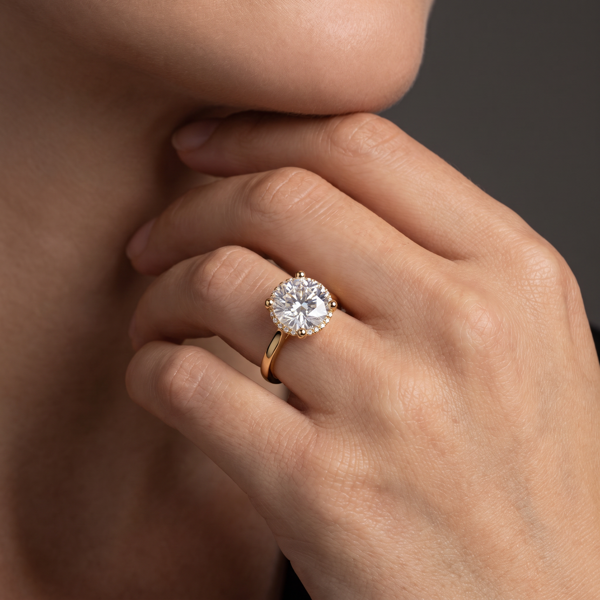 Hand wearing a 2.5 carat round Lab-Grown Diamond hidden halo engagement ring in 14K yellow gold