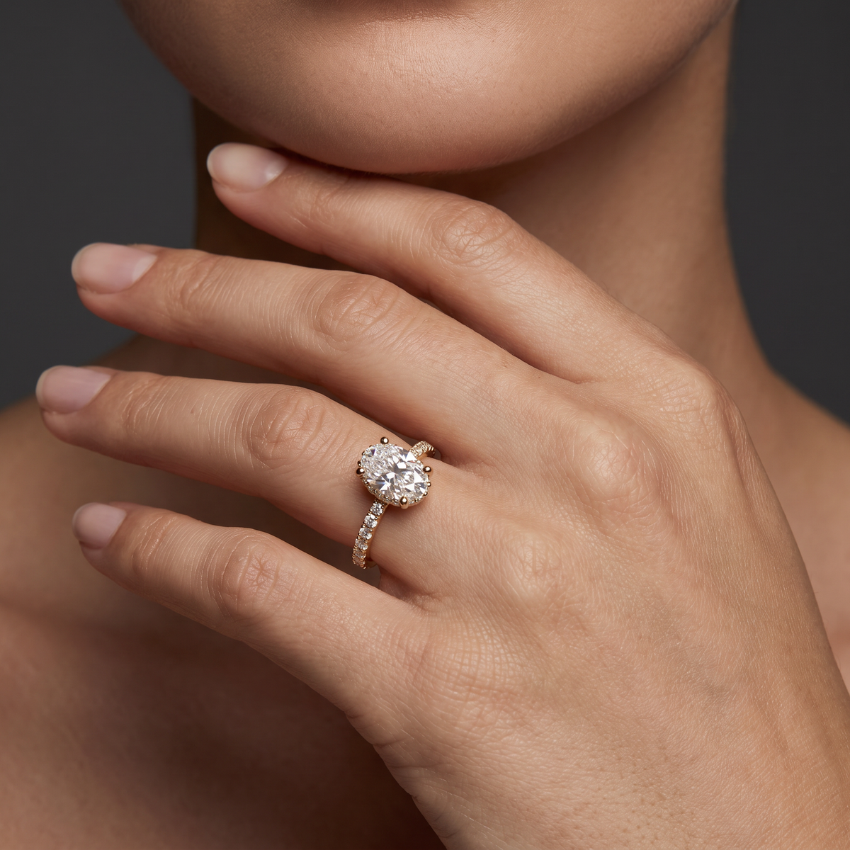 2 carat oval Lab-Grown Diamond engagement ring worn on hand, 14K rose gold with pavé band, shown for scale