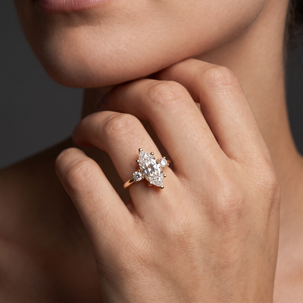 Woman wearing a 2ct marquise three-stone engagement ring in 14K yellow gold, showing the 13mm Lab-Grown Diamond center on the finger