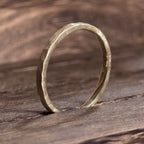 Side view of 2mm hammered gold wedding ring with organic matte finish, modern handcrafted band from Black Pearl of Queens.