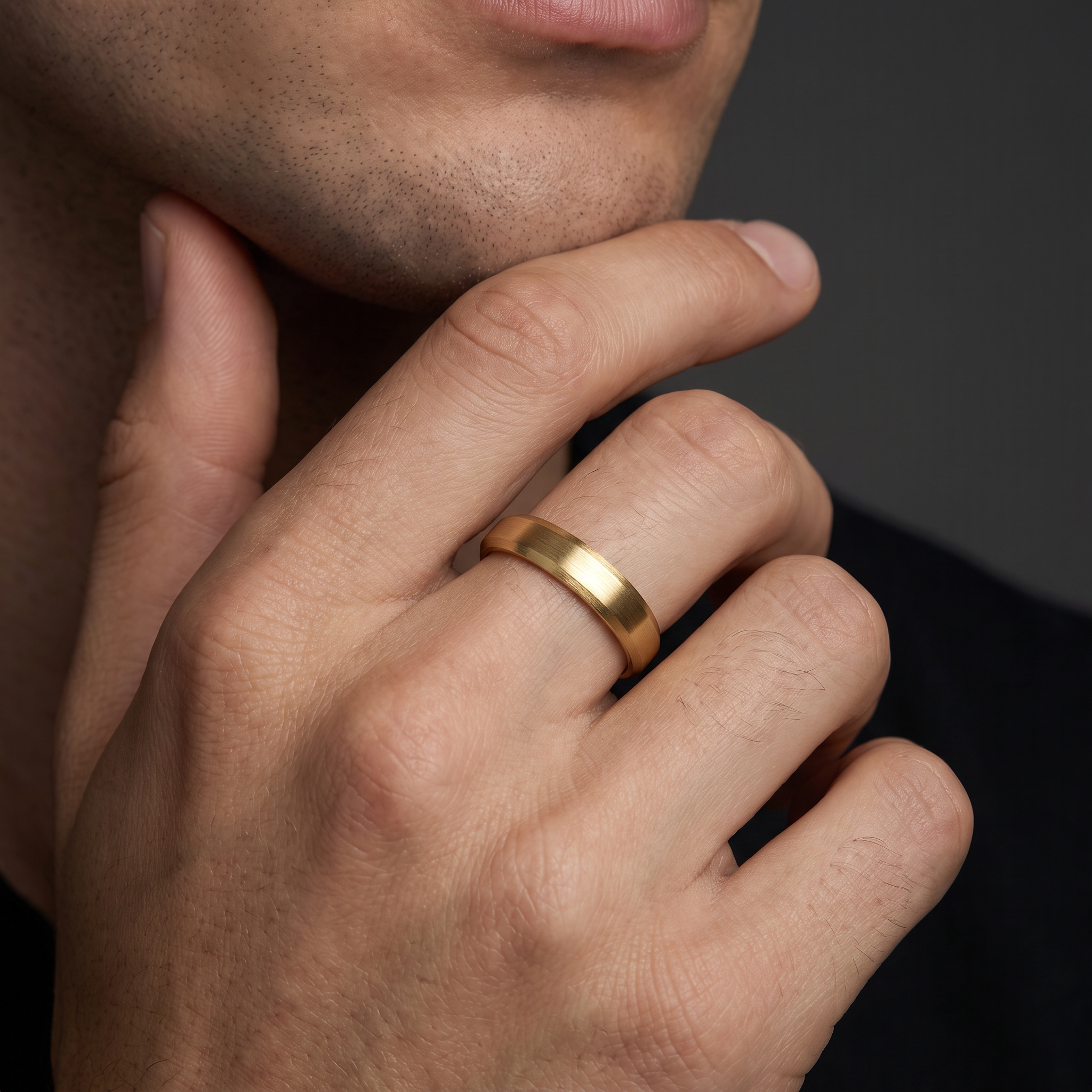 Man wearing the 4mm satin beveled edge wedding band in 14K yellow gold