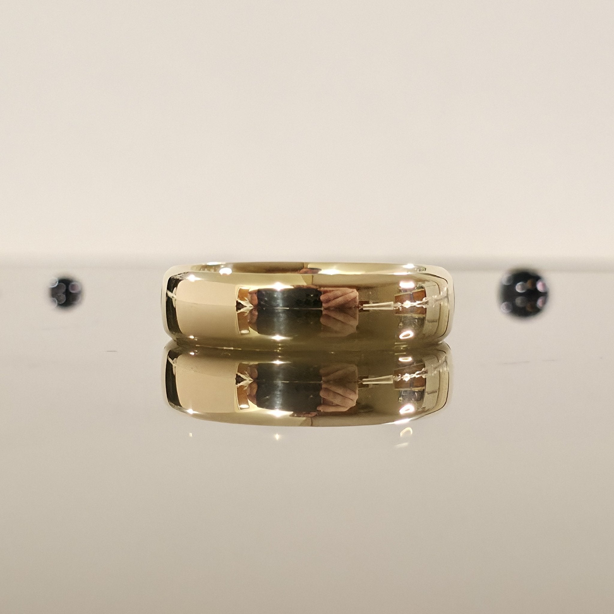 rounded edge 6mm comfort fit wedding ring in gold laid down and closed up view - Black Pearl of Queens