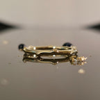 Organic bamboo-inspired gold ring on reflective surface, minimalist wedding band design