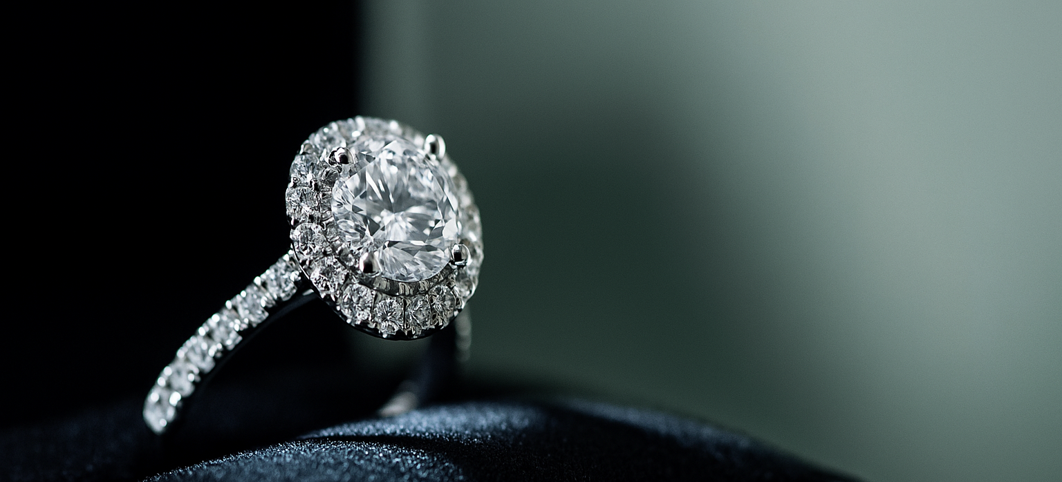 Halo Diamond ring on a black cushion with a blurred green background