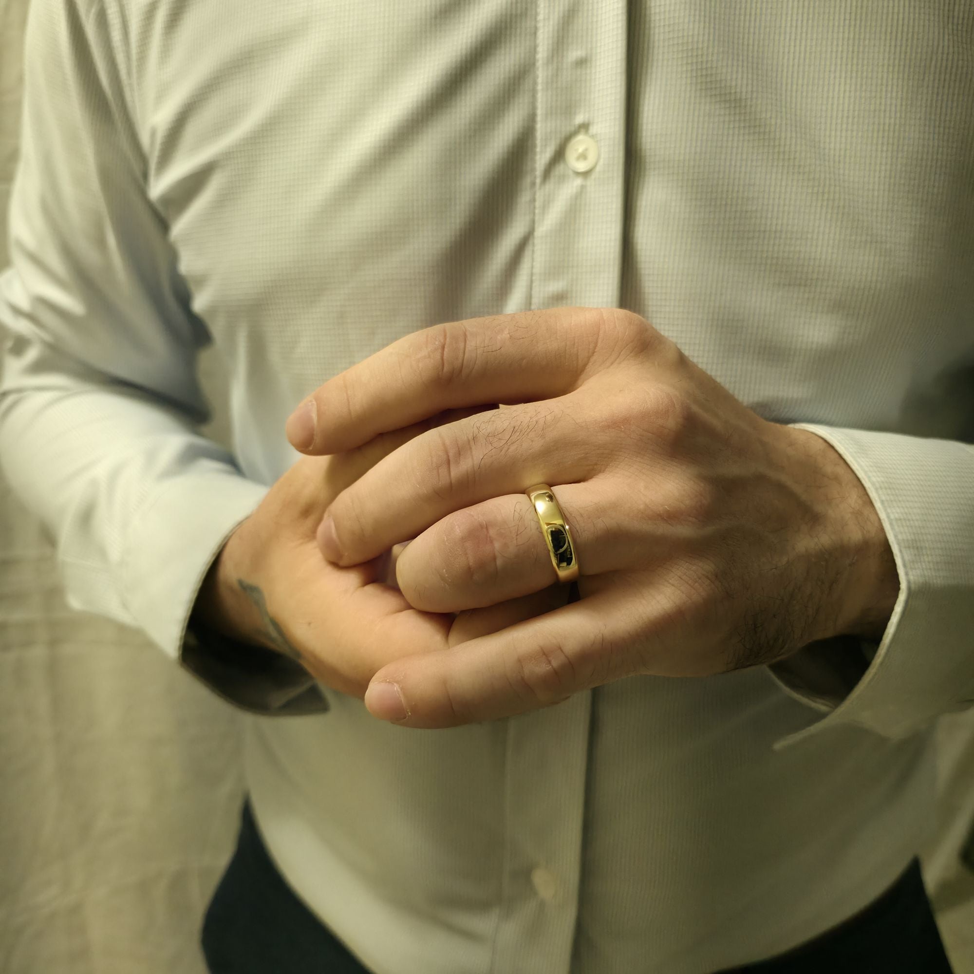 Man wearing a 6mm comfort fit wedding ring in 14K yellow gold, classic band with softly rounded edges and smooth polished finish.