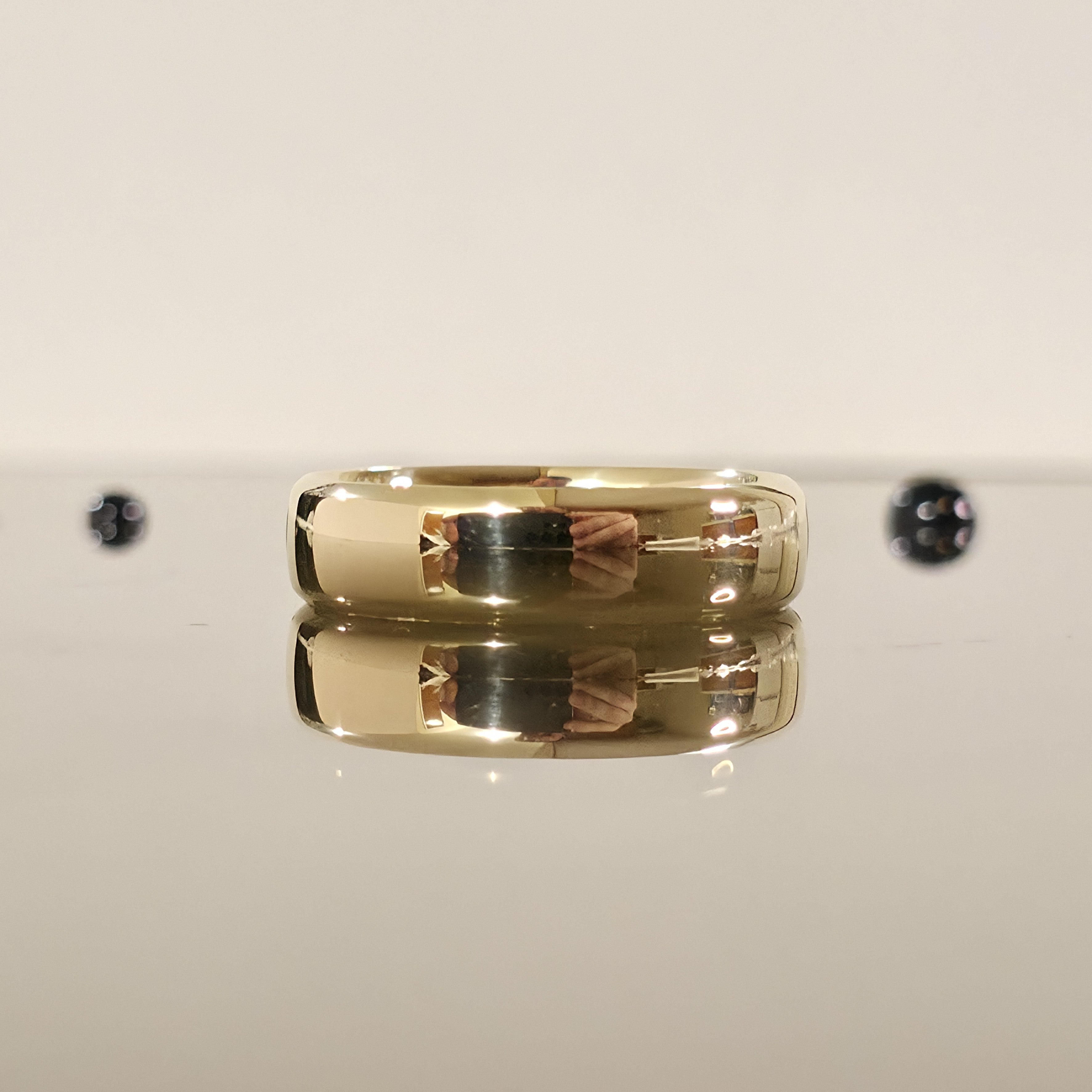 rounded edge 6mm comfort fit wedding ring in gold laid down and closed up view - Black Pearl of Queens