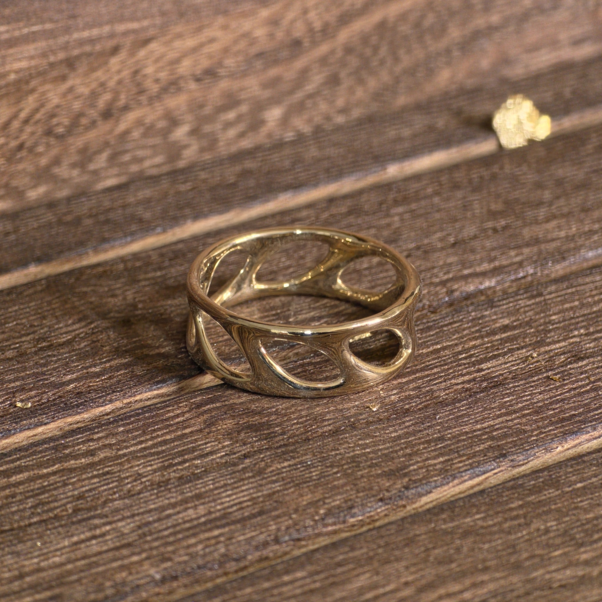 14K gold openwork olive leaf band ring on wood background