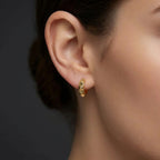 Woman wearing Apex Studded Huggie Earrings in 14K gold, everyday modern huggie earrings style