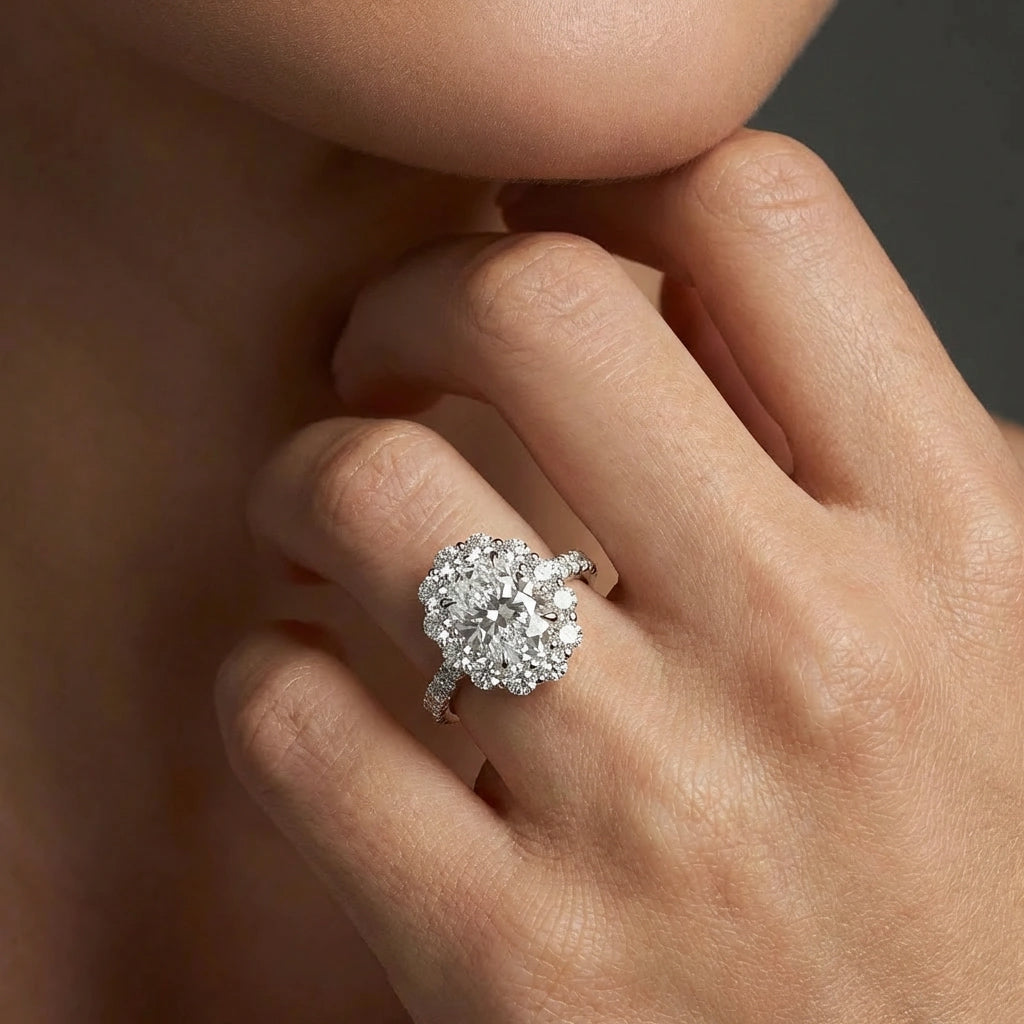 Woman wearing Aurelia Bloom oval diamond engagement ring on hand, floral halo engagement ring style