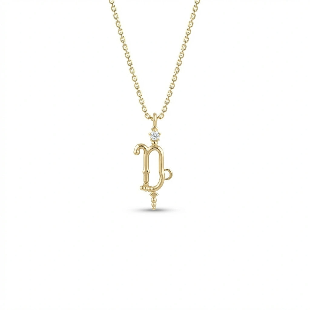 Aurex Capricorn Zodiac Diamond Necklace in 14K yellow gold, front view showing sculptural Capricorn glyph with diamond crown and beaded drop on cable chain