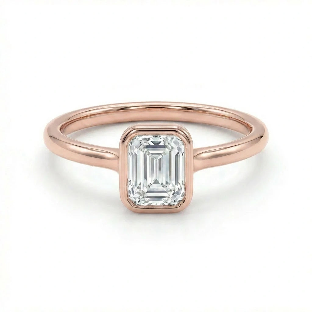 Solid 14K rose gold emerald cut diamond ring with bezel setting and polished slim band