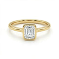 Solid 14K yellow gold emerald cut diamond ring with bezel set center stone and sleek band