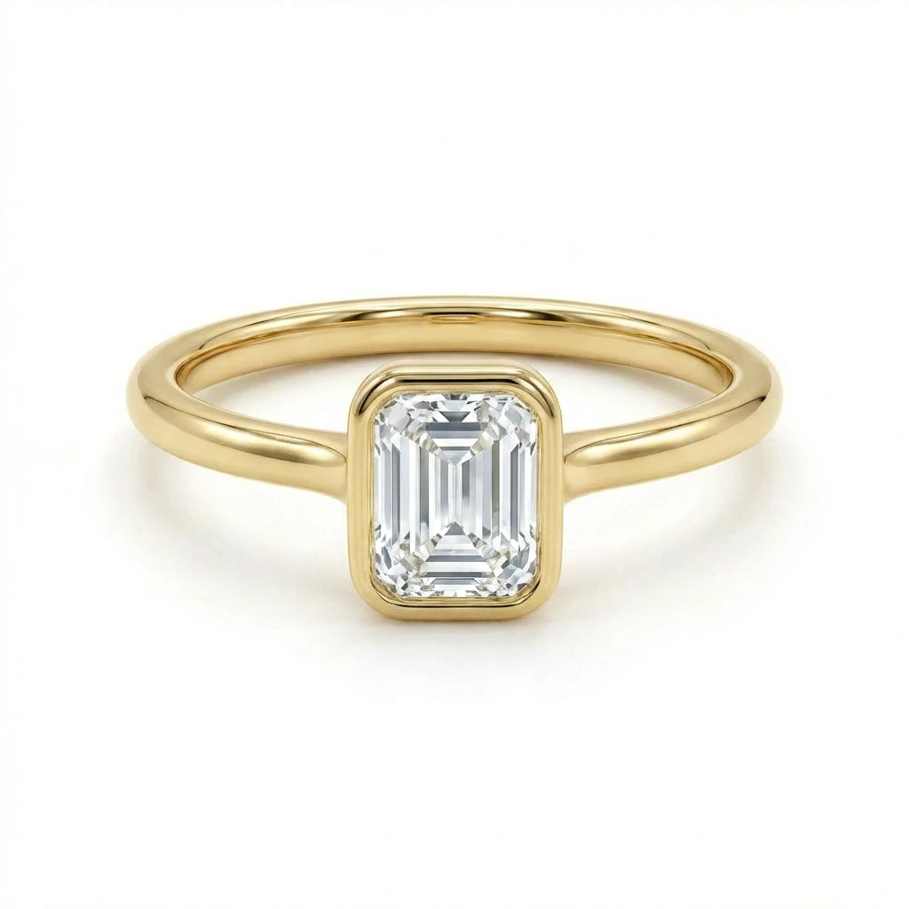 Solid 14K yellow gold emerald cut diamond ring with bezel set center stone and sleek band