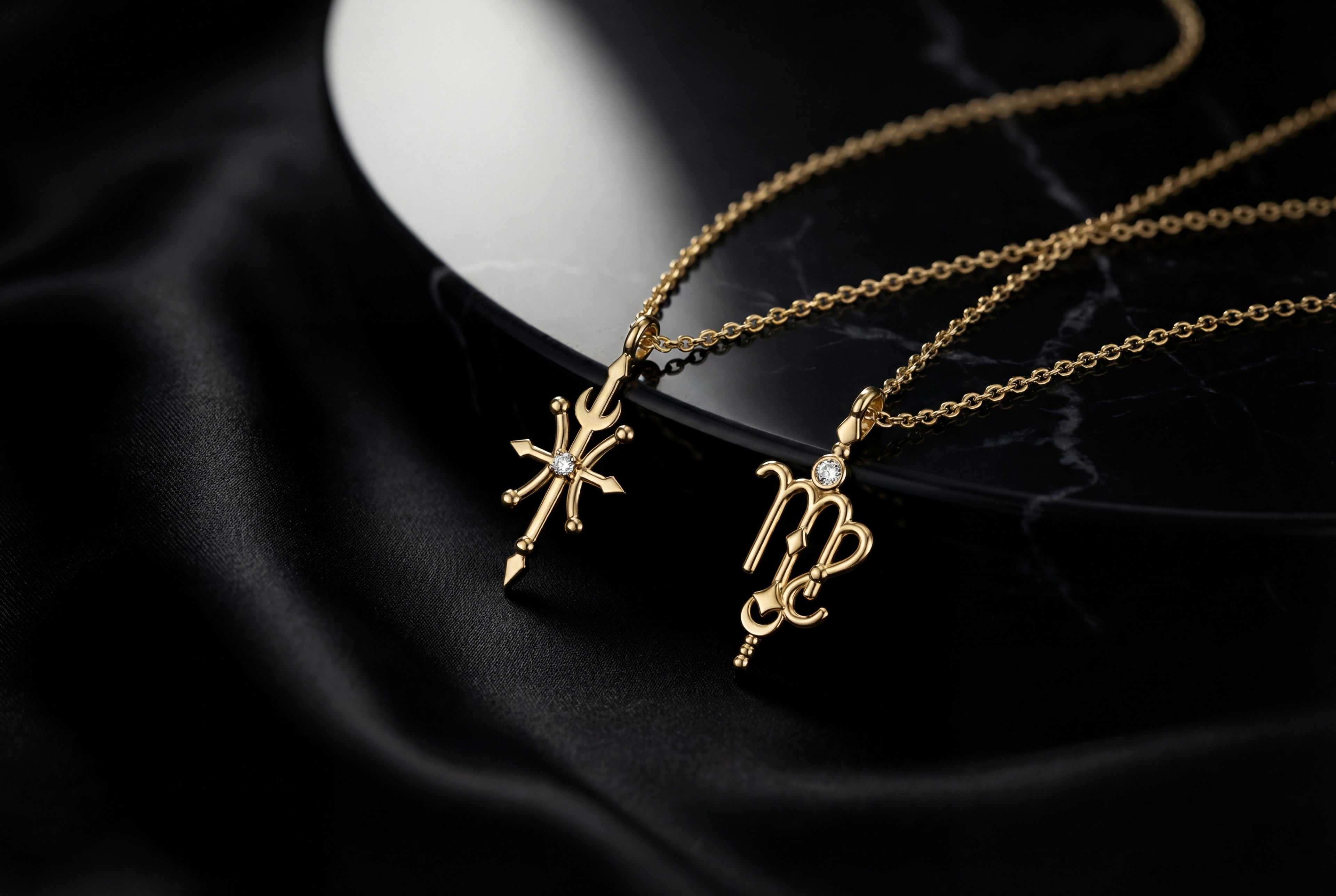 Aurex collection 14K gold zodiac pendant necklaces with diamond accents on black silk background