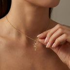 Model wearing Aurex Taurus Zodiac Diamond Necklace in 14K yellow gold at décolletage, close-up editorial shot showing bull horns symbol with center diamond and black diamond-shaped bail