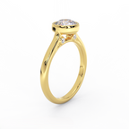 Bezel set round diamond solitaire ring in 14K yellow gold showing diamond under gallery detail