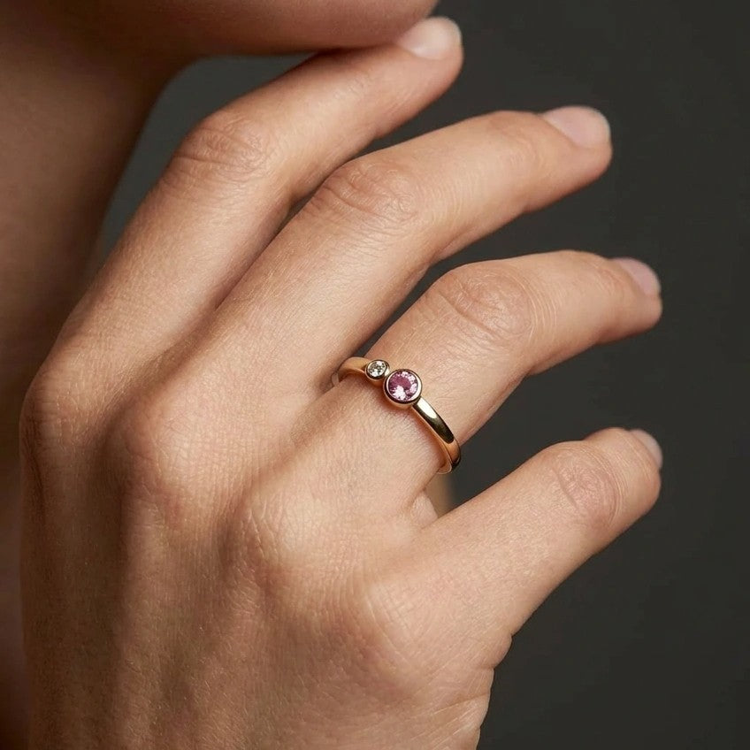 Woman wearing blush duo bezel diamond and pink sapphire ring in yellow gold