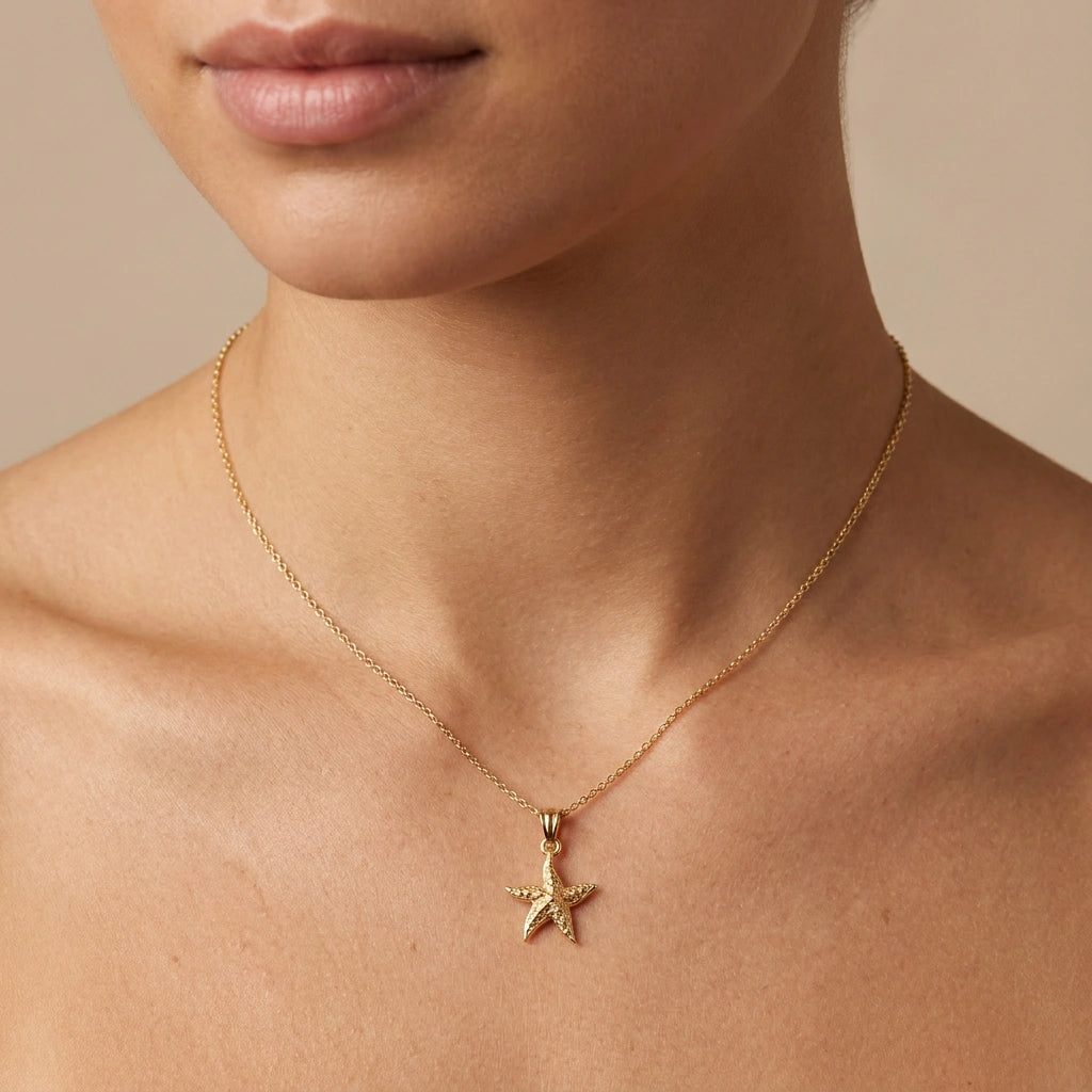 Model wearing a 14K yellow gold starfish necklace on an adjustable cable chain — Black Pearl of Queens