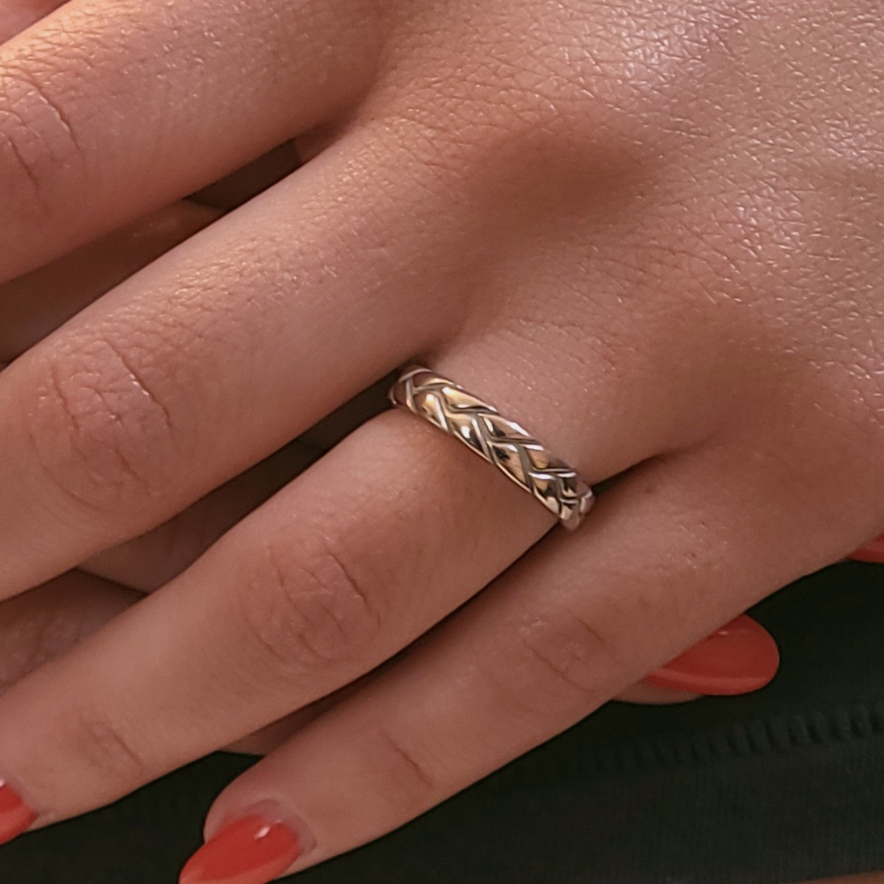 Braided 14K gold band worn on hand showing woven texture and slim profile

