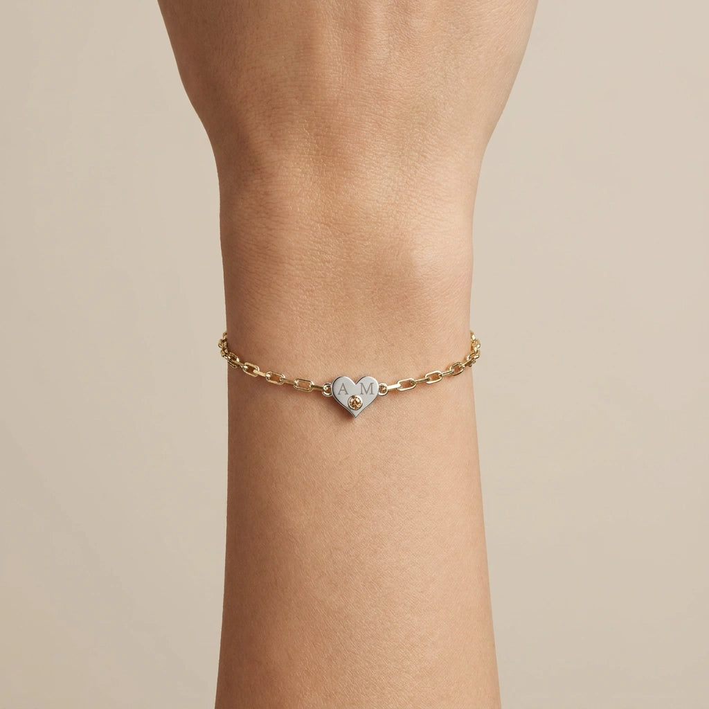 Brownstone champagne diamond heart bracelet with engraved initials worn on wrist — front view on neutral background, 14K white and yellow gold