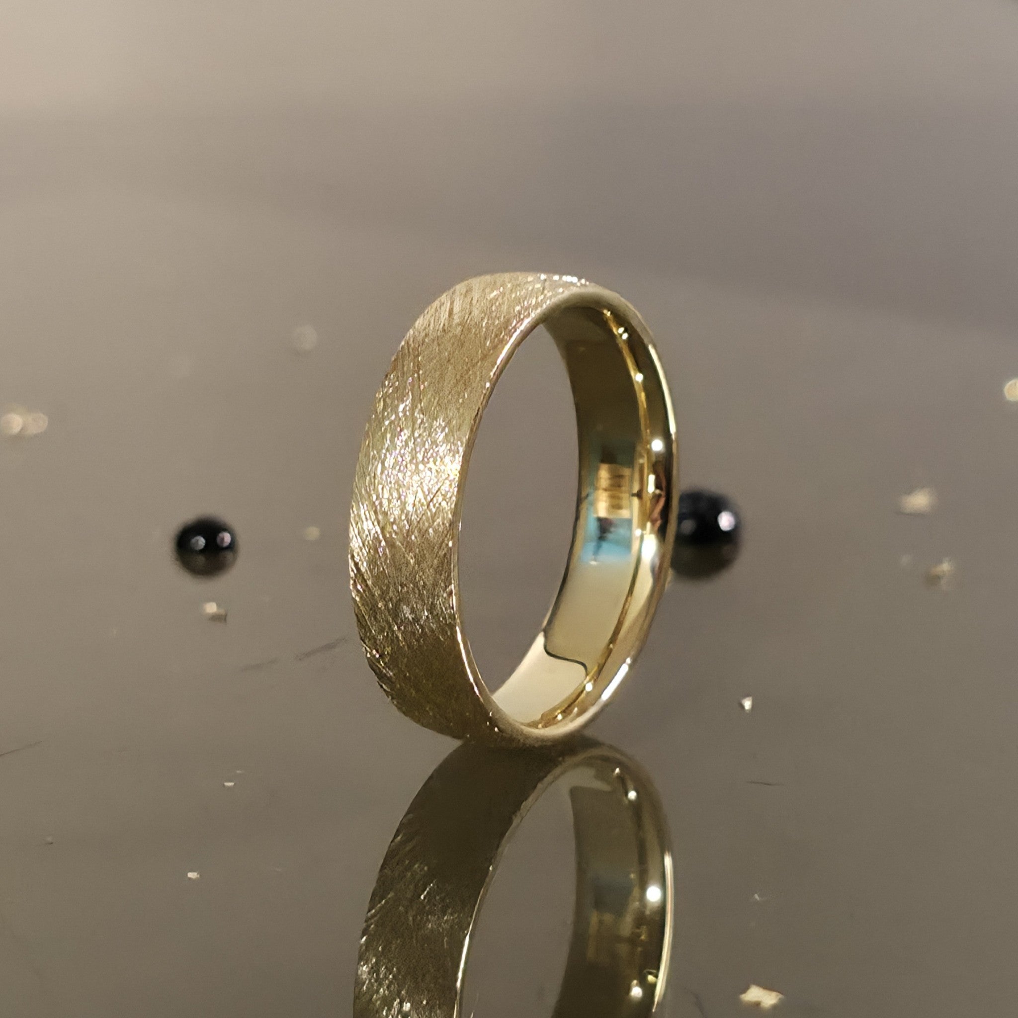 6mm brushed gold wedding band standing upright showing matte texture and comfort fit interior