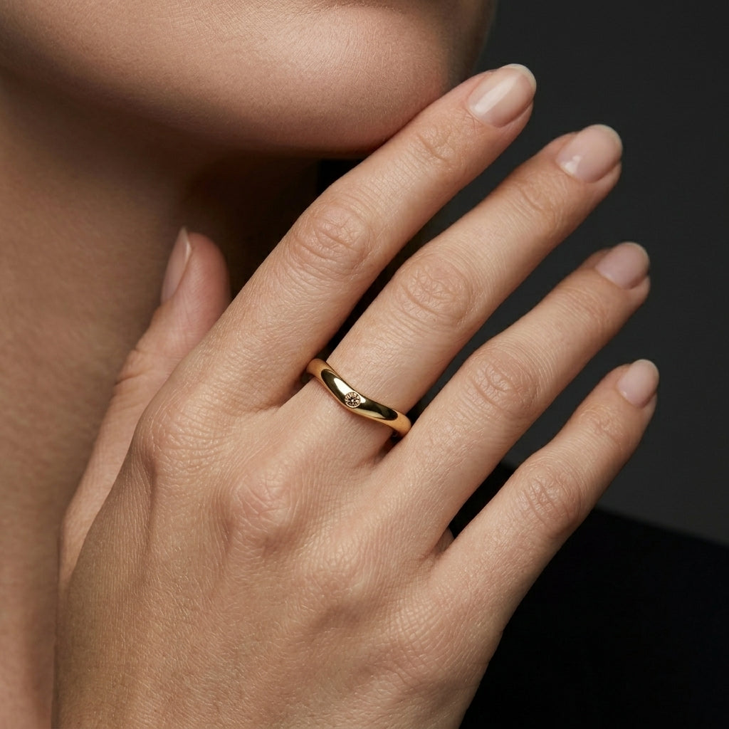 Champagne diamond curved wedding band in 14K yellow gold worn on the hand, flush-set natural champagne diamond contour band