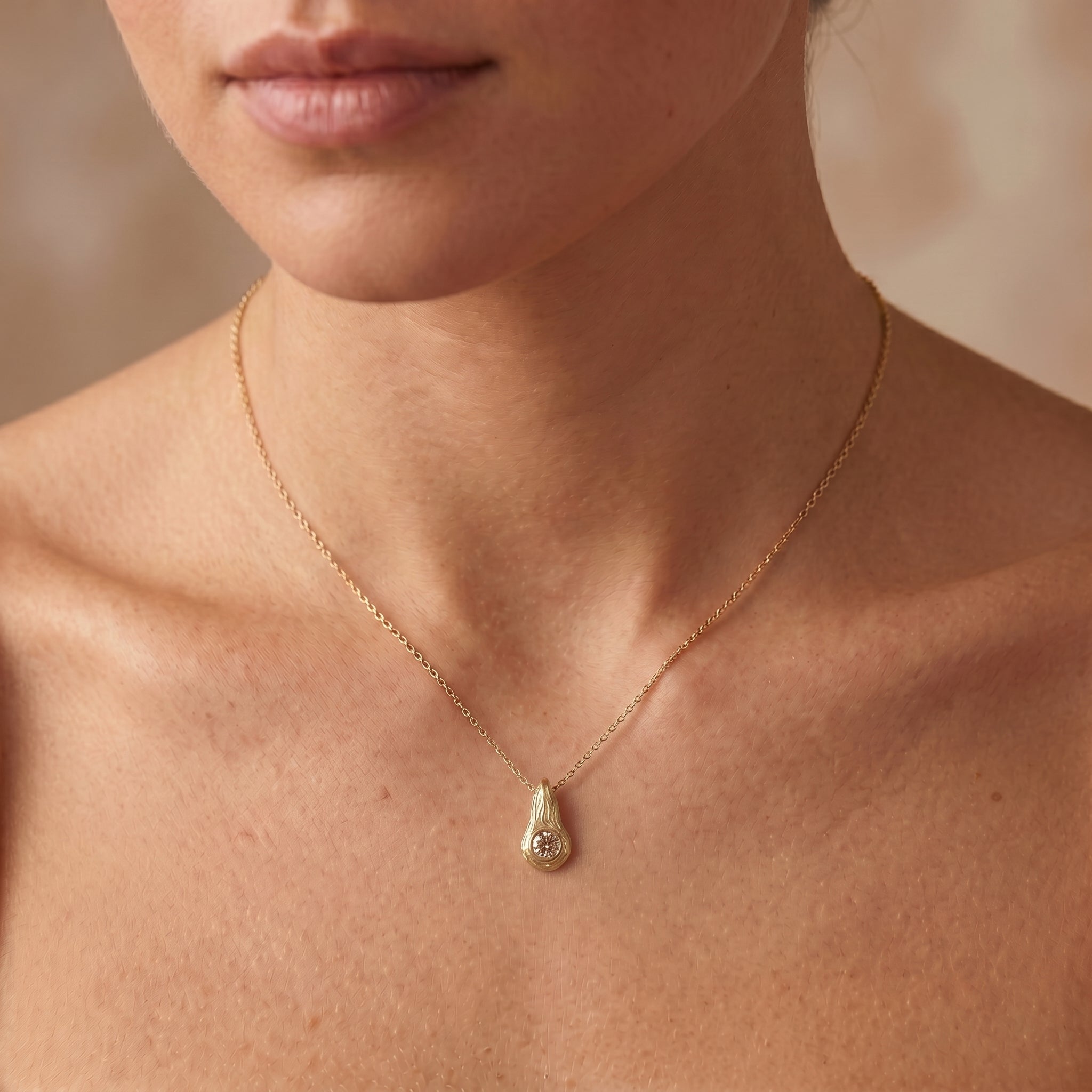 Champagne diamond Ember pendant worn on the neck, 14K yellow gold flame design