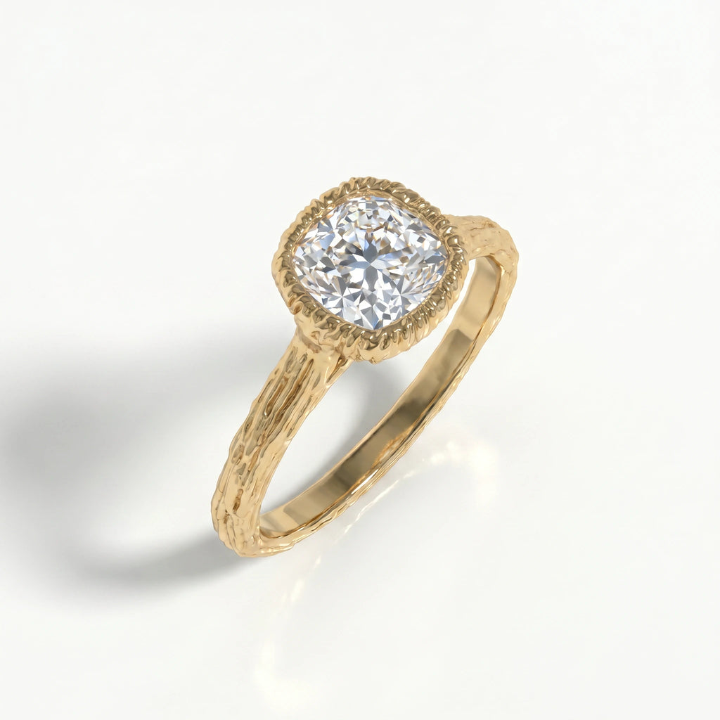 Cushion Cut Lab-Grown Diamond engagement ring, angled view of the bezel-set stone and bark-textured branch band in 14K yellow gold