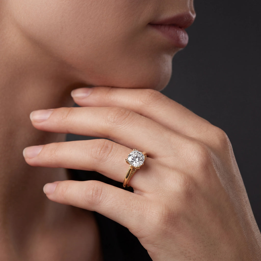 Model wearing cushion cut lotus prong milgrain Lab-Grown Diamond engagement ring in 14K yellow gold, close-up showing petal prong setting and gallery detail — Black Pearl of Queens