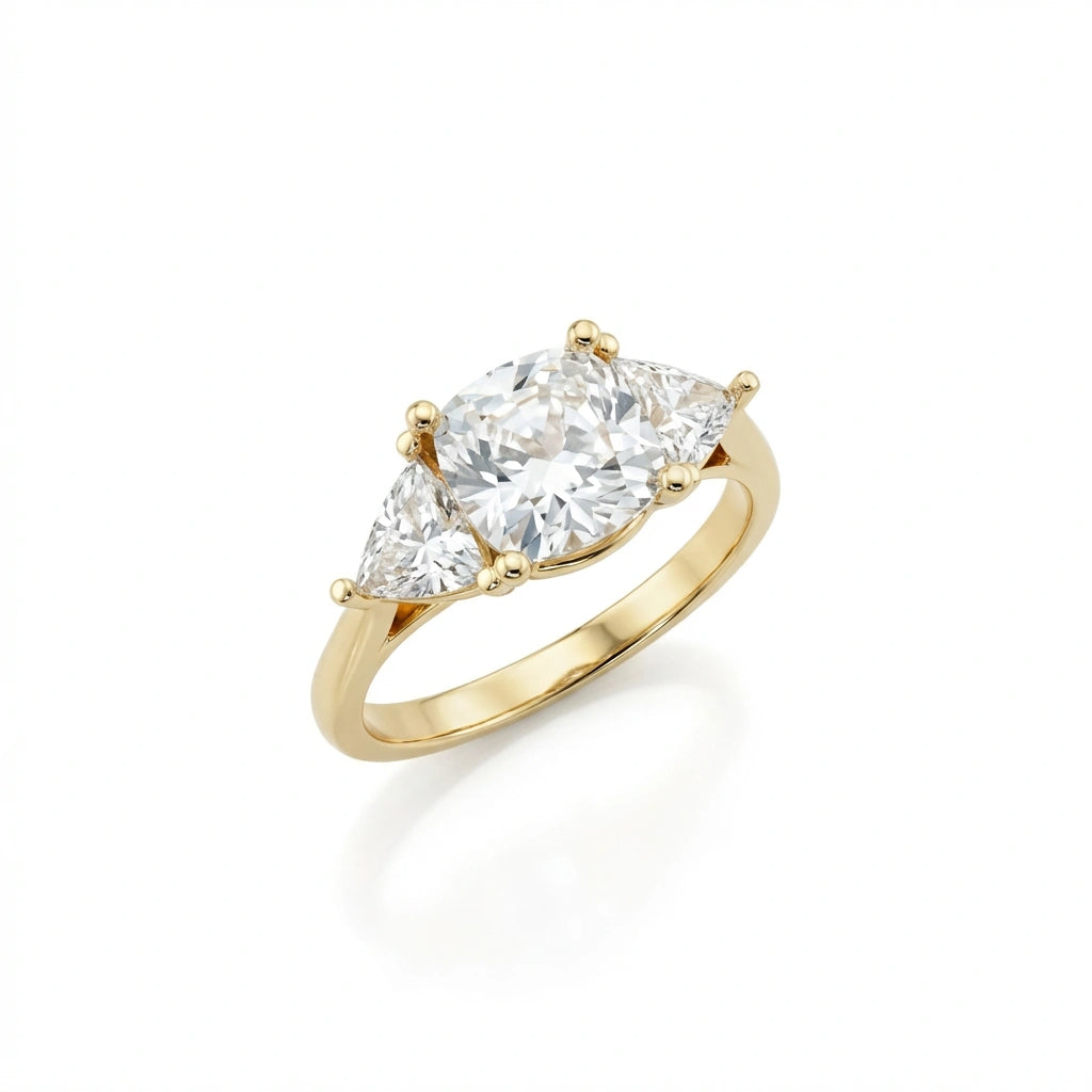 Angled view of the cushion three-stone engagement ring in 14K yellow gold with trillion side stones
