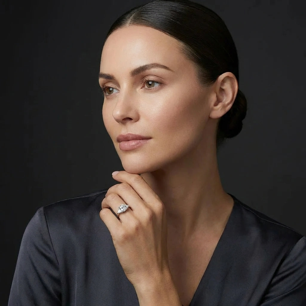 Woman wearing the 2ct cushion three-stone engagement ring in white gold, showing the span across the finger