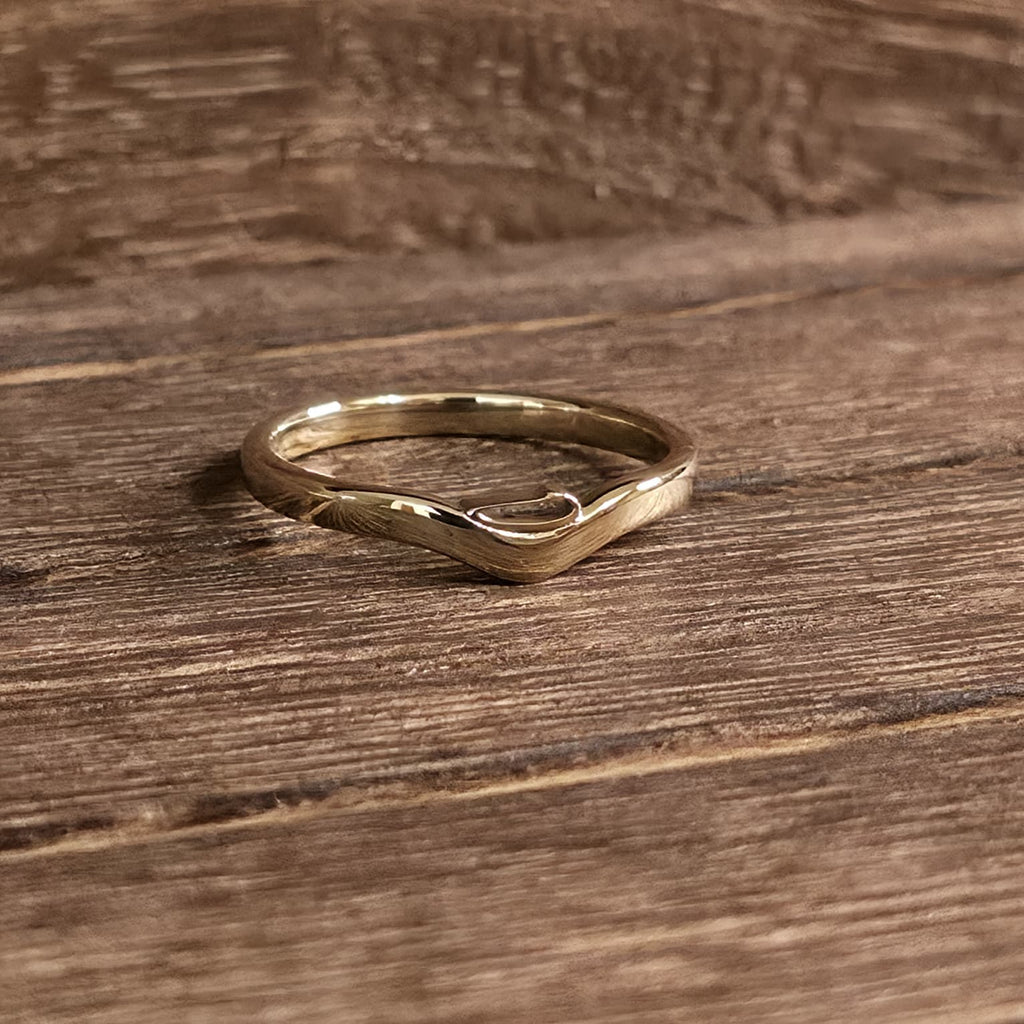 D initial ring solid 14K gold version on wood surface showing curved band and polish – Black Pearl of Queens
