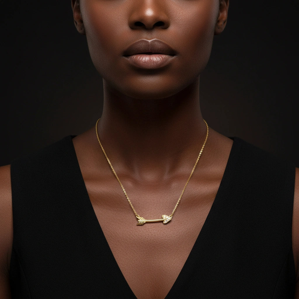 Luxury portrait of model wearing 14K gold diamond arrow necklace against dark background