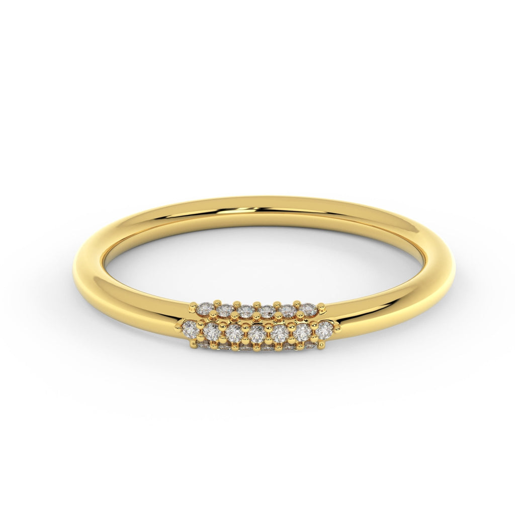 Diamond wire ring in 14K yellow gold with petite cluster of diamonds, slim 2mm wire wedding ring close-up on white surface
