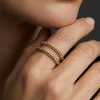 Woman wearing stacked rope rings in gold with twisted design and minimalist style